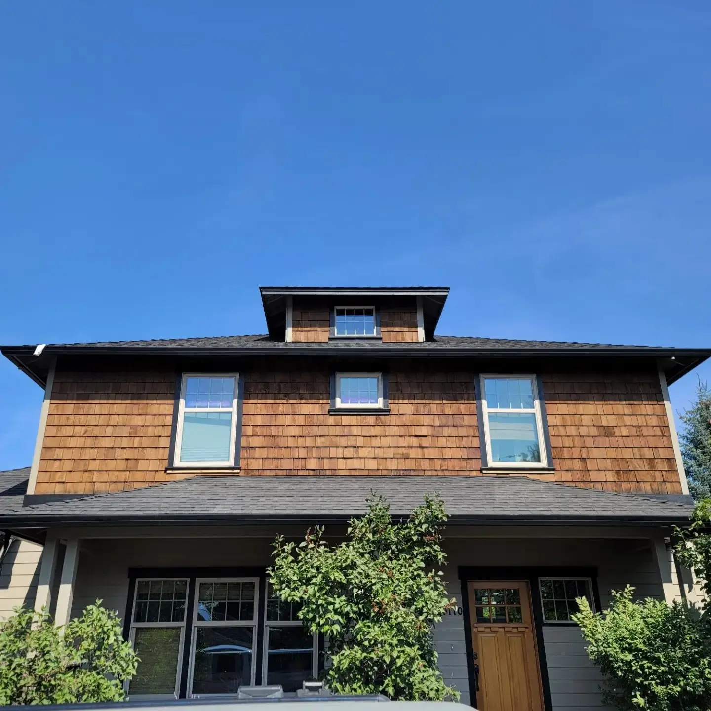 Front perspective of a Bend residence featuring freshly stained upper-level cedar shingles and matching trim.