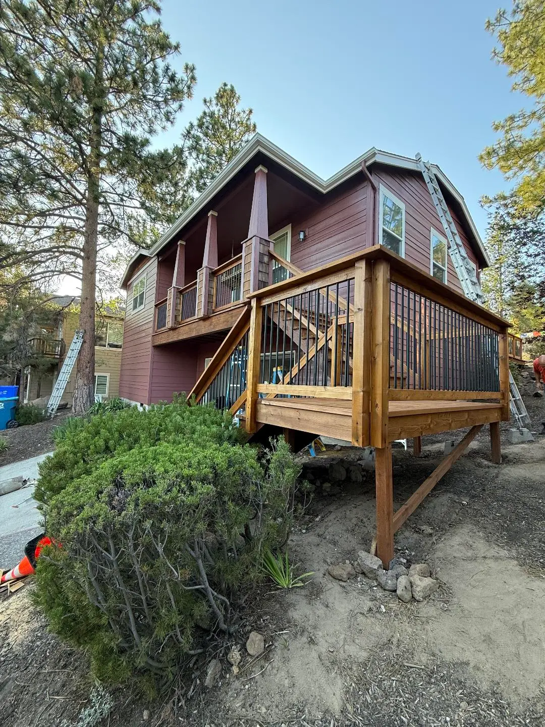Professionally stained and finished wooden deck with black metal balusters on a Central Oregon home.