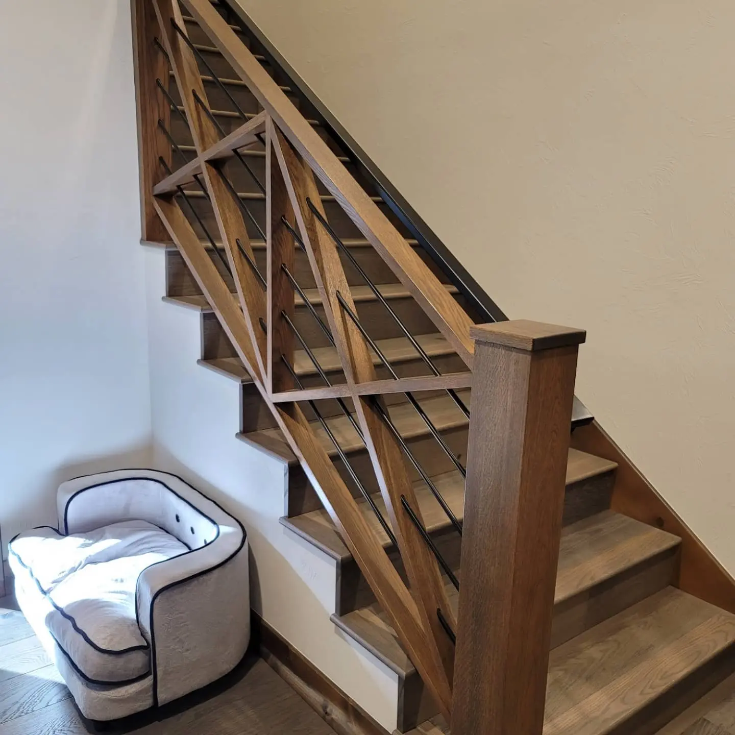 Detailed craftsmanship on a custom 'X' design wood stair railing with black metal balusters in Sunriver.