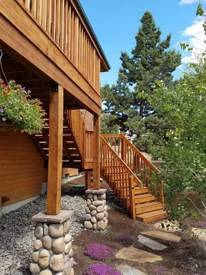 Detailed view of stained wooden stairs and supporting pillars on a multi-story Central Oregon home.