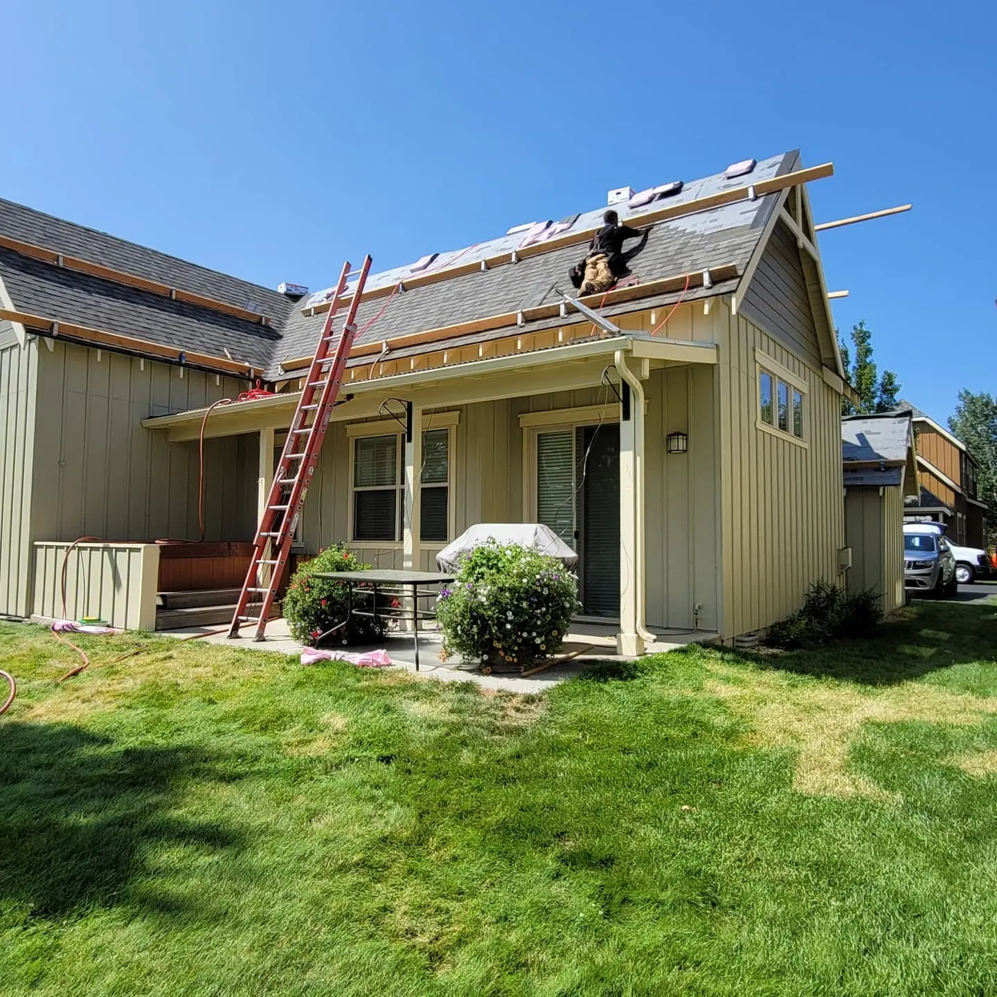 Professional painters finishing the roofline and gables of a Redmond house after restoration work.