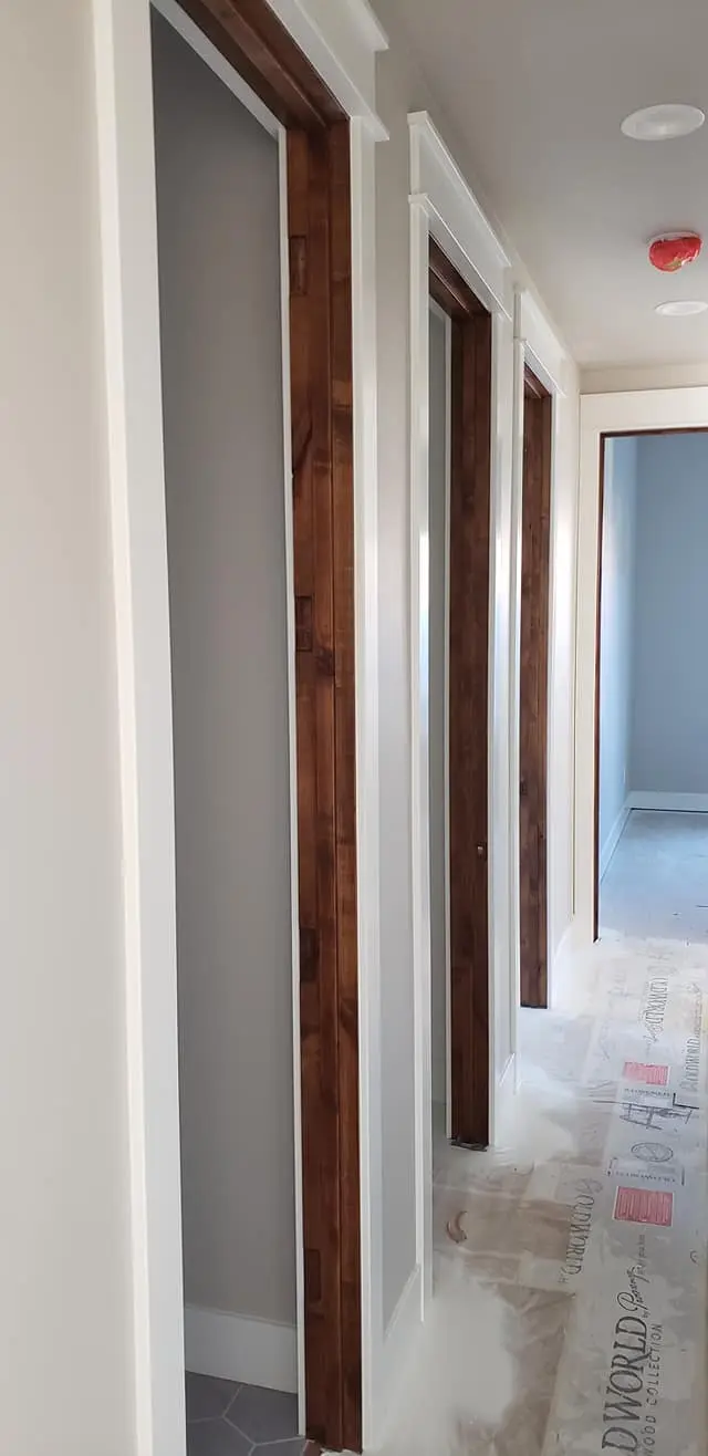 Long hallway view showcasing white painted door trim contrasting with stained wood interiors.