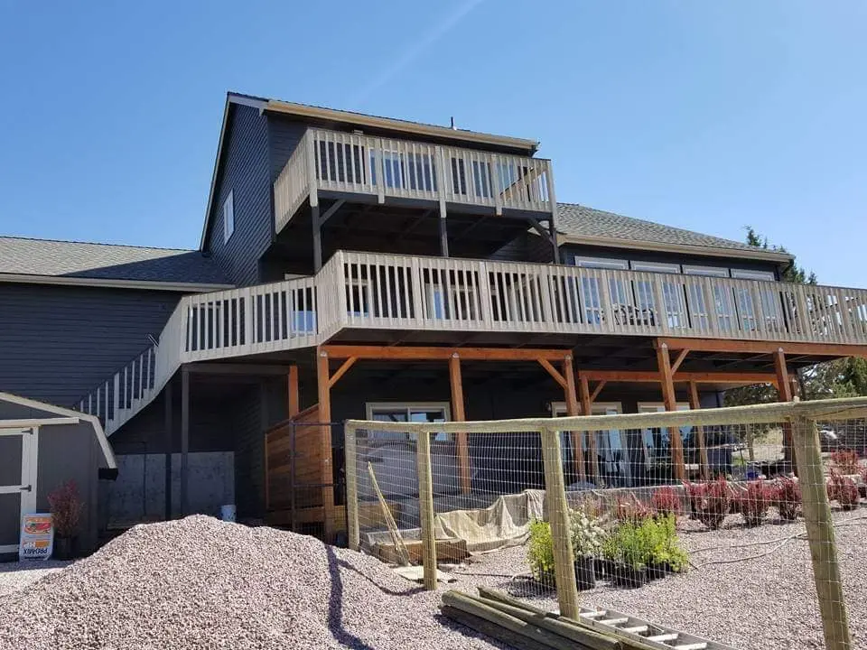 Low angle view of the expansive rear deck and support structure after professional staining and painting