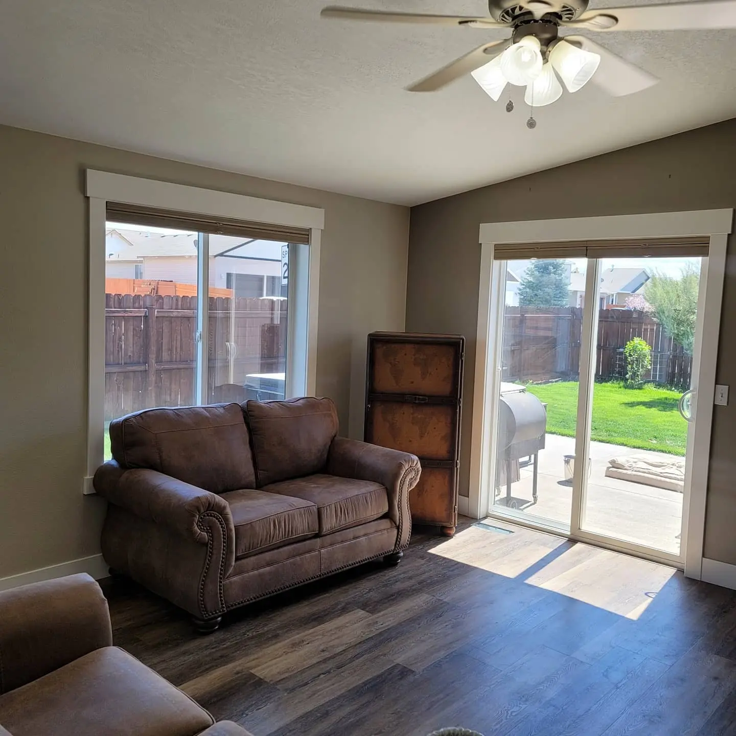 Completed living room update in Redmond with grey walls, white trim, and a modern ceiling fan.