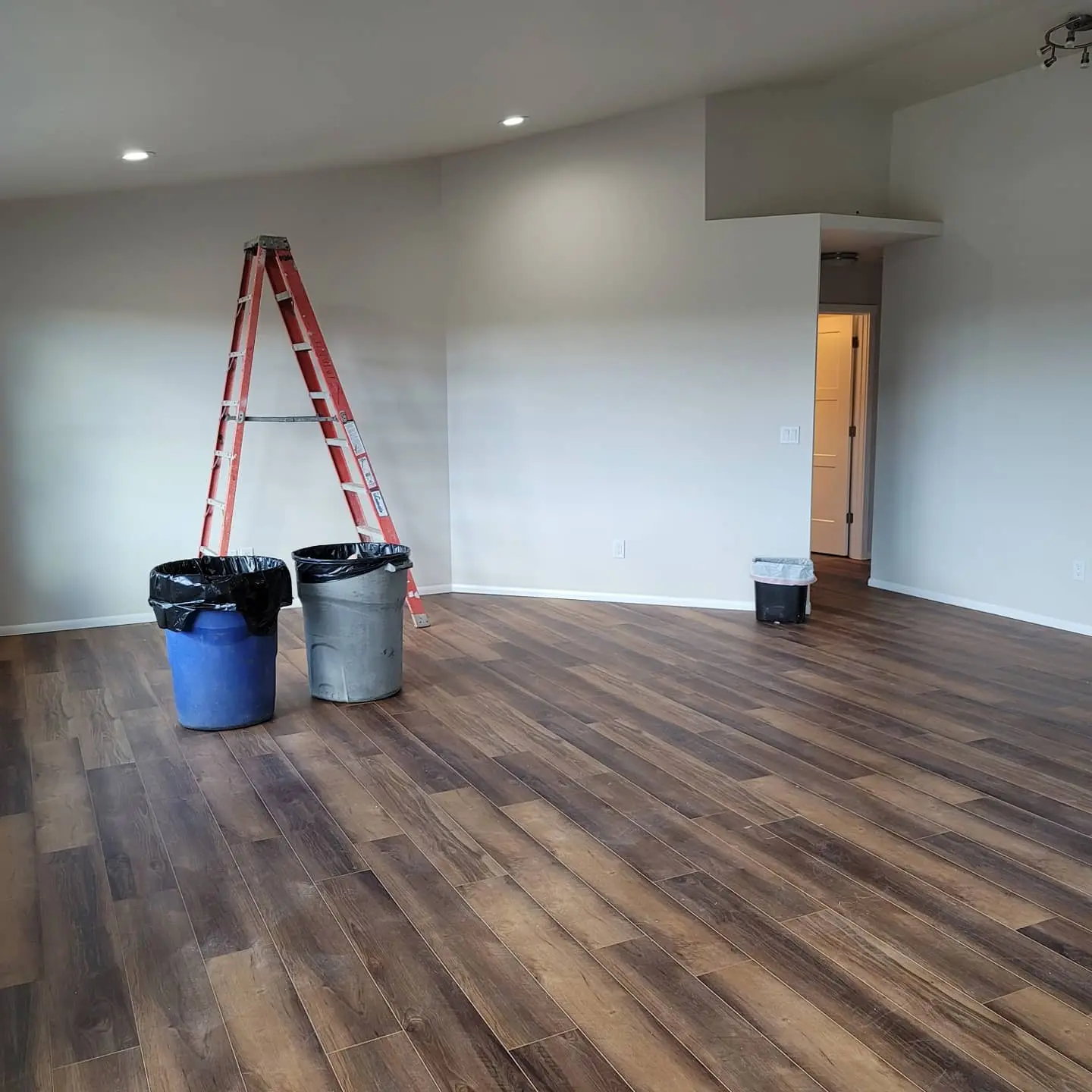 Large living space with vaulted ceilings and walls painted in a neutral, modern palette