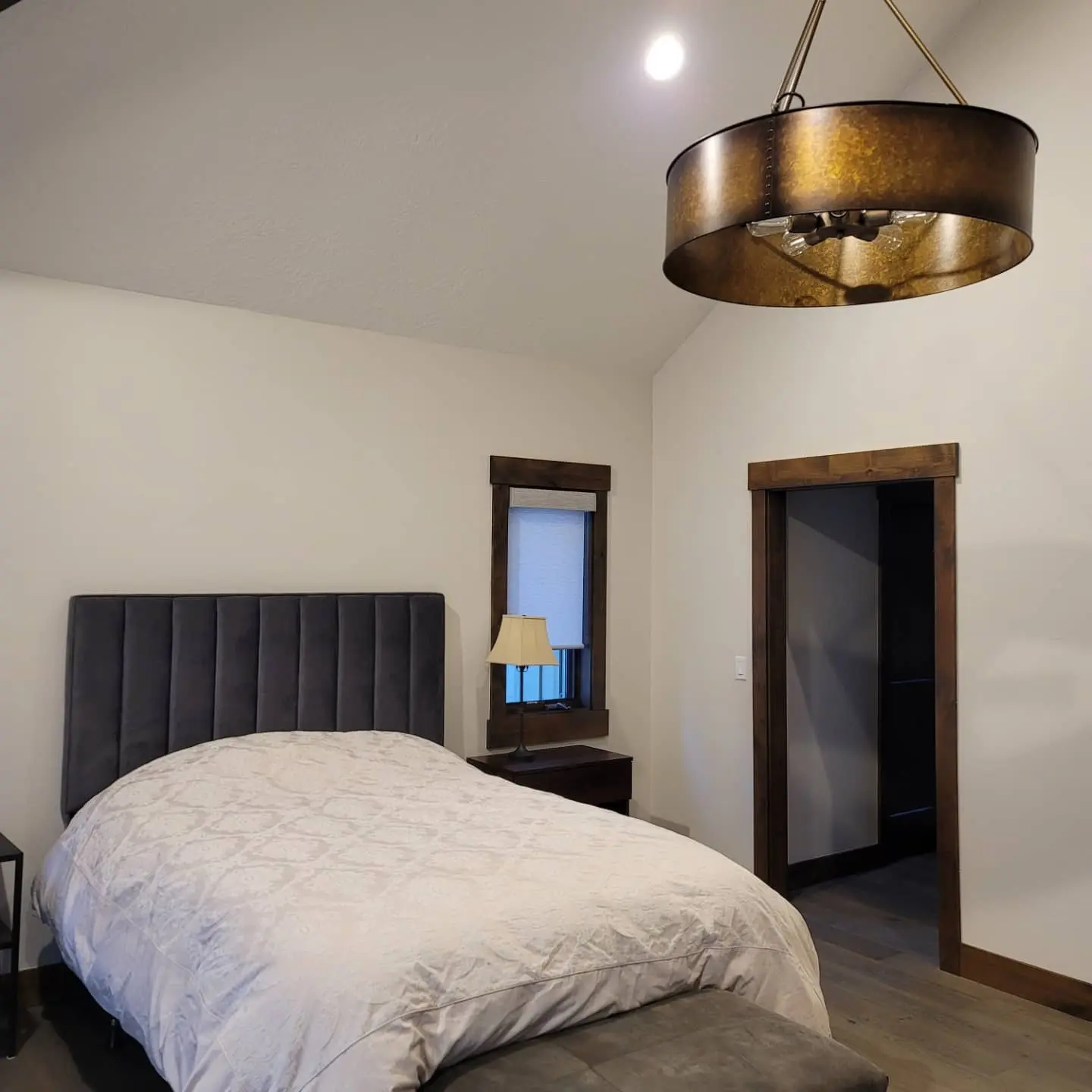View of a luxury master bedroom in Sunriver showing the seamless transition from wood flooring to custom trim.
