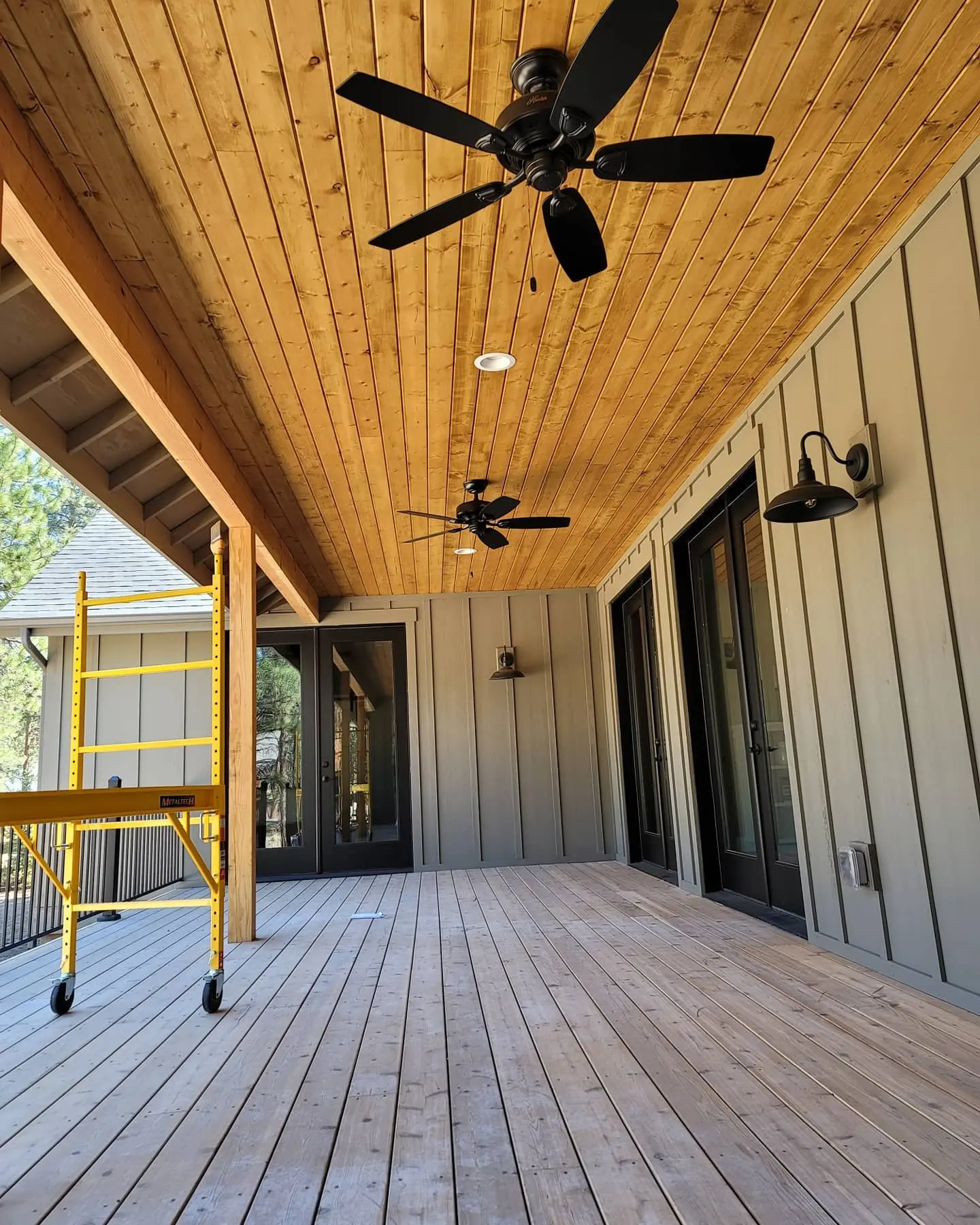 Completed deck and porch area in Sisters showing the contrast between olive siding and natural wood stained ceilings.