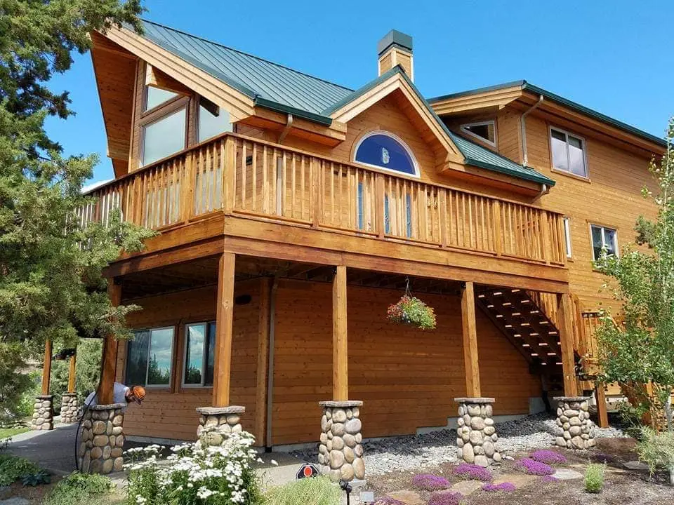 View of a large multi-level wooden deck with a fresh golden-brown stain finish in Central Oregon.