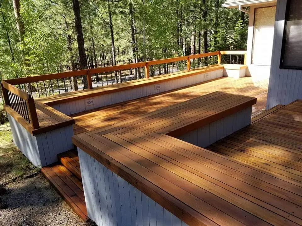 Expansive multi-level deck featuring uniform staining on all surfaces and integrated wooden benches