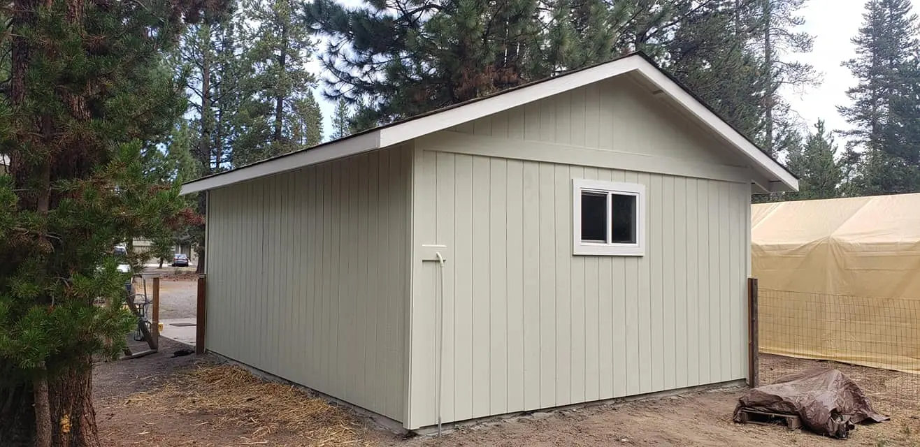 Back view of a painted outbuilding in La Pine demonstrating consistent color across all property structures.