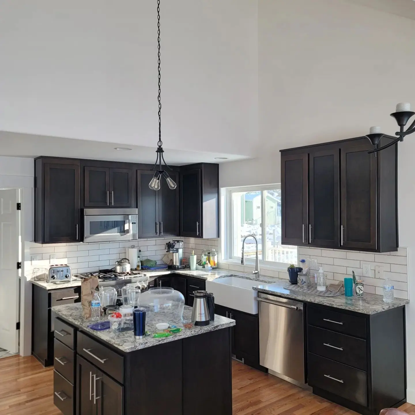 Remodeled kitchen in Powell Butte with dark custom cabinets, white subway tile, and a large farmhouse sink.