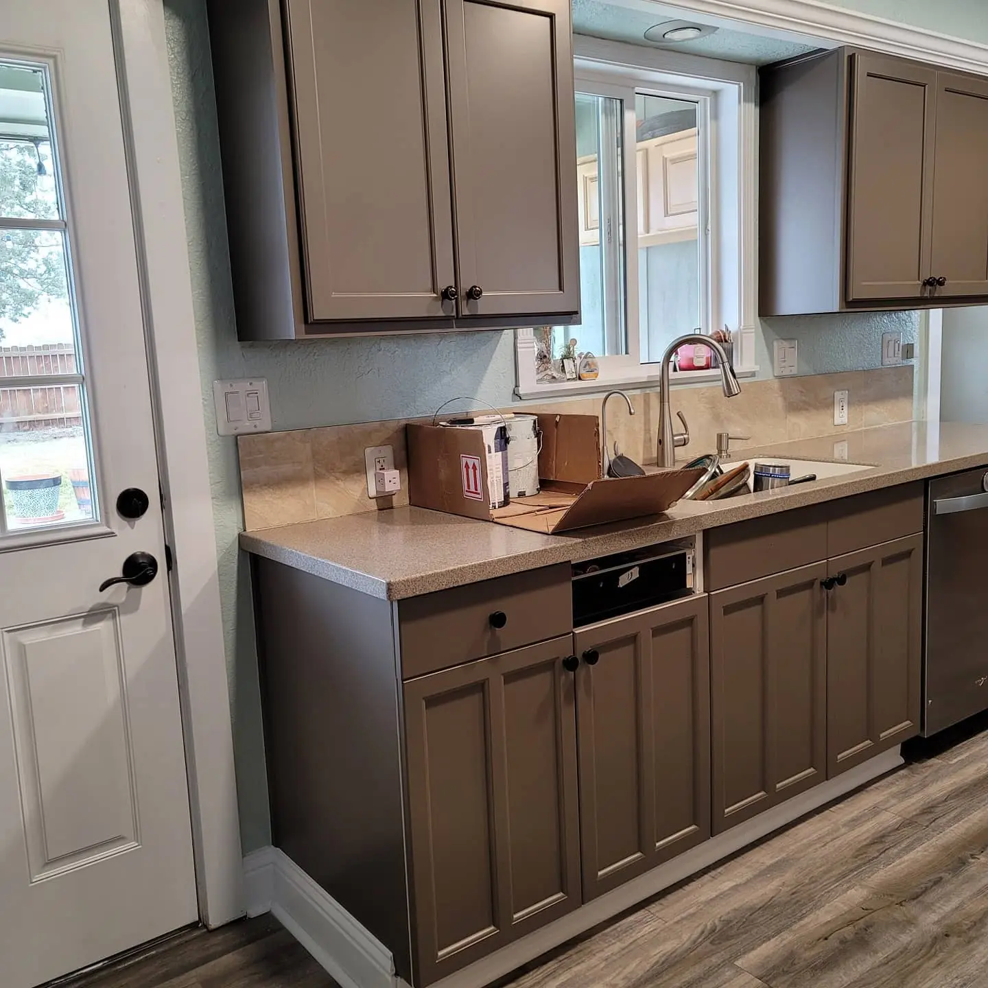 Sophisticated grey lacquer finish on kitchen island cabinetry with updated fixtures