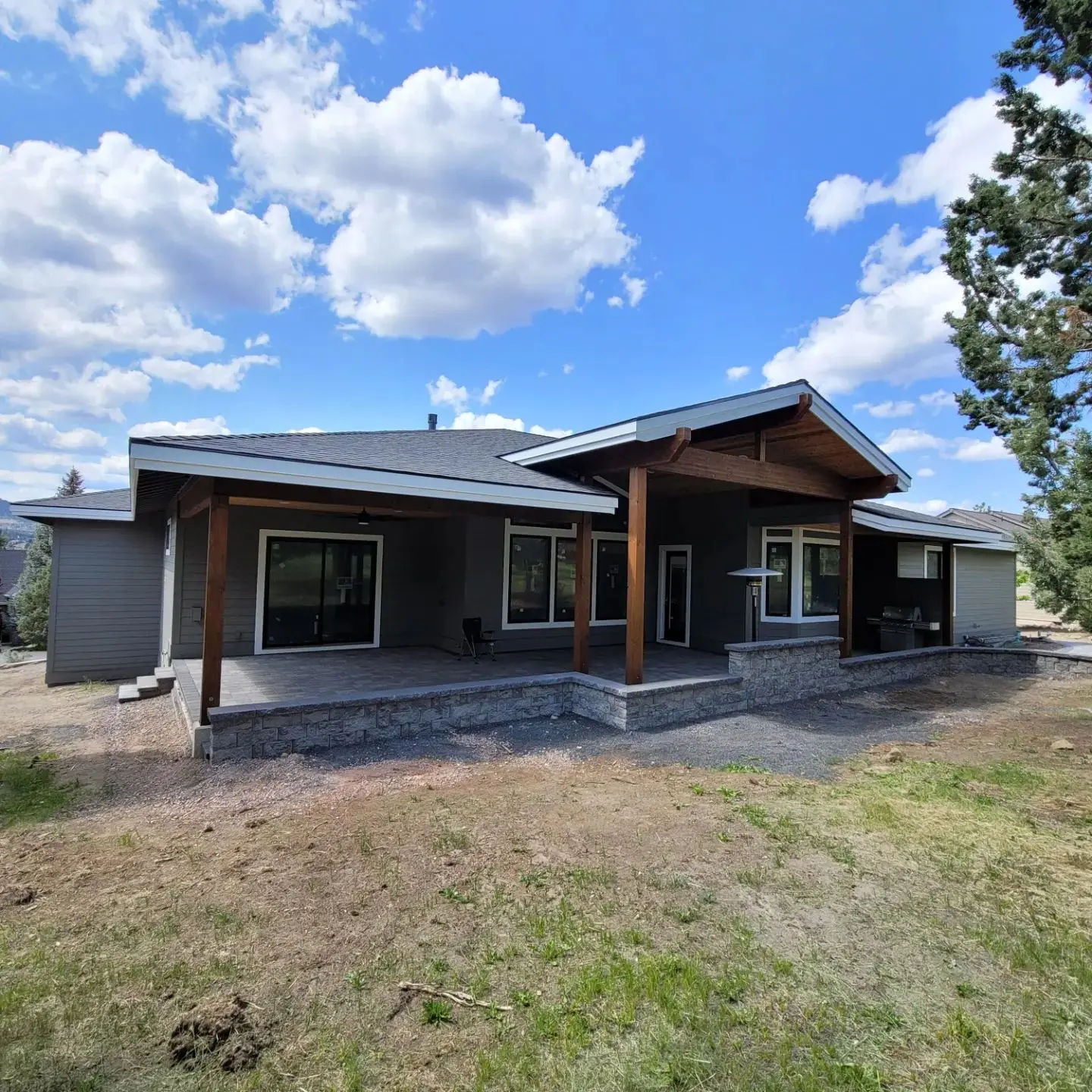 Rear view of a luxury Redmond home with integrated stone retaining walls and extensive outdoor living space.