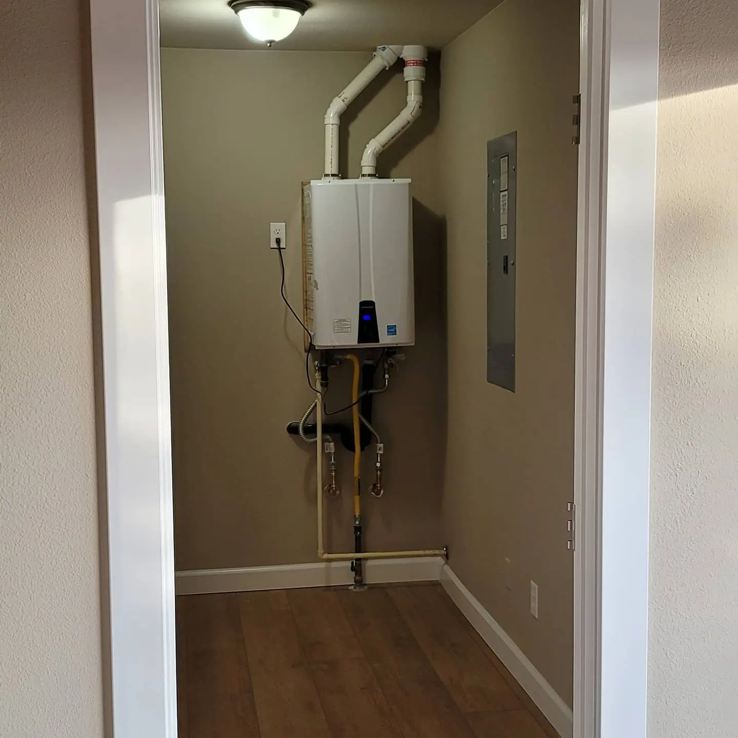 Clean interior painting for a utility closet area featuring a tankless water heater