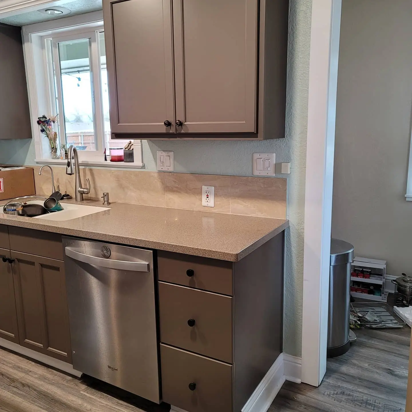 Crisp white pigmented lacquer on upper cabinets paired with a stone tile backsplash