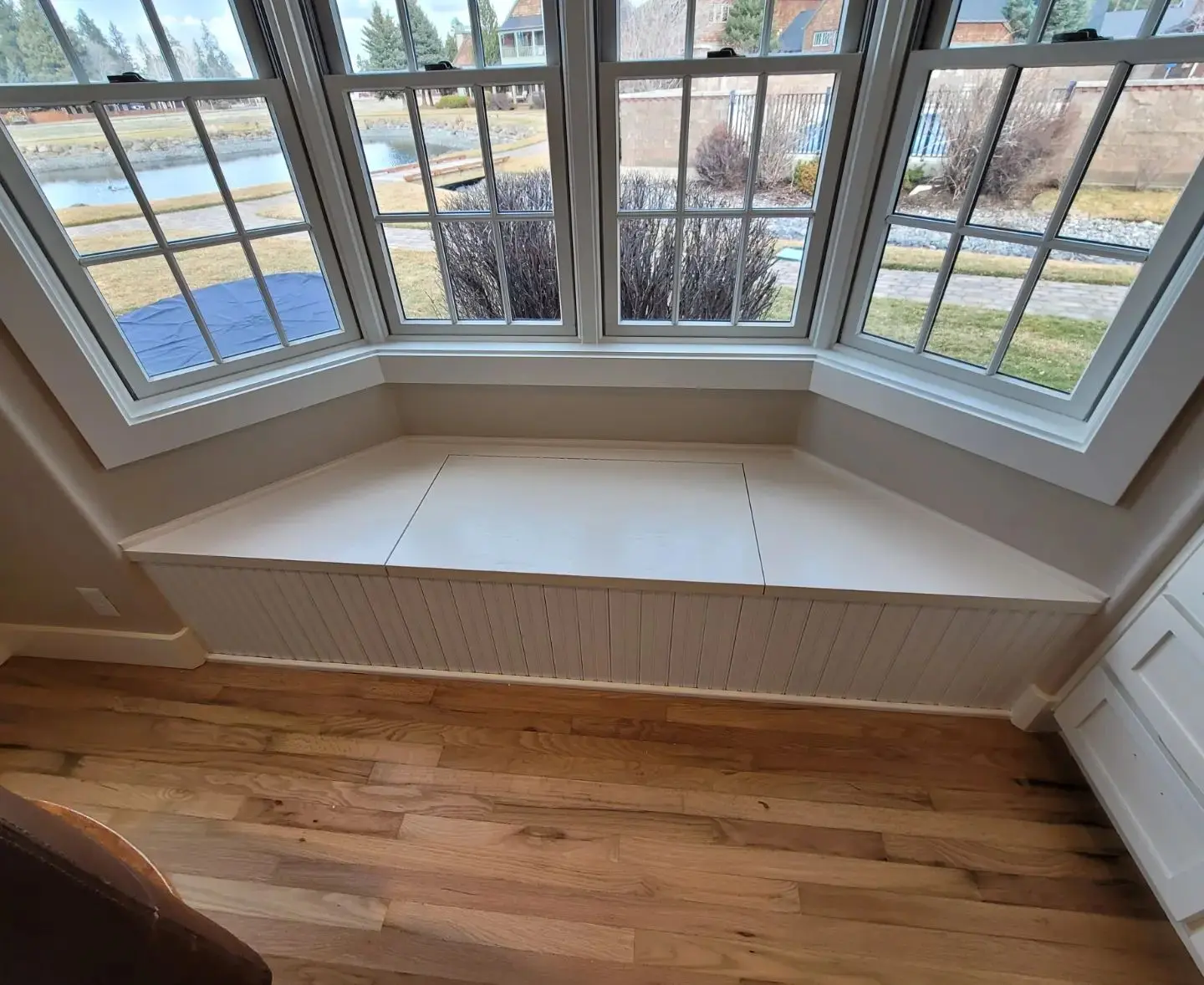 Custom bay window storage bench with white Miller Evolution trim and beadboard panels in Sisters.
