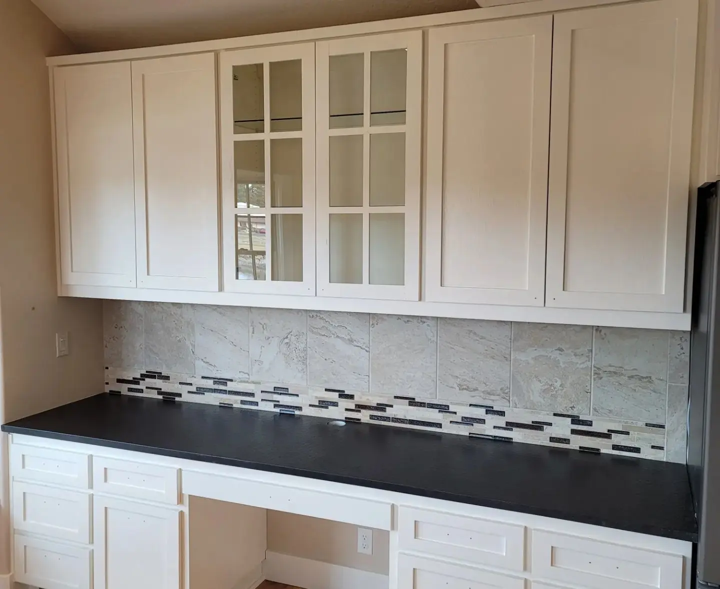 Upper kitchen cabinets with glass inserts finished in premium white lacquer in Sisters OR.