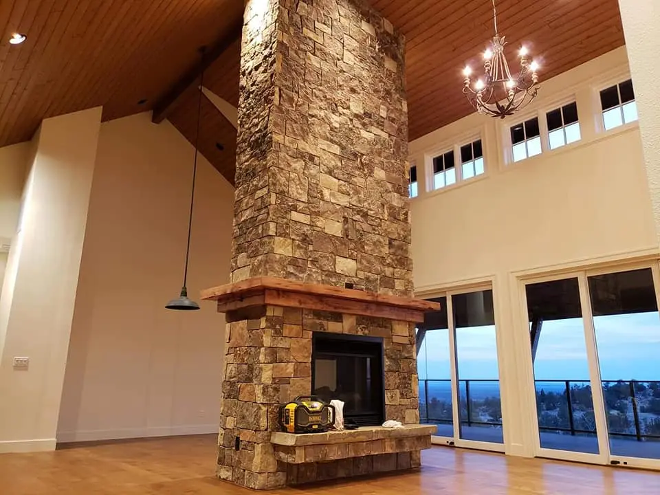 Detailed view of a floor-to-ceiling natural stone fireplace in a custom-painted Brasada Ranch home.