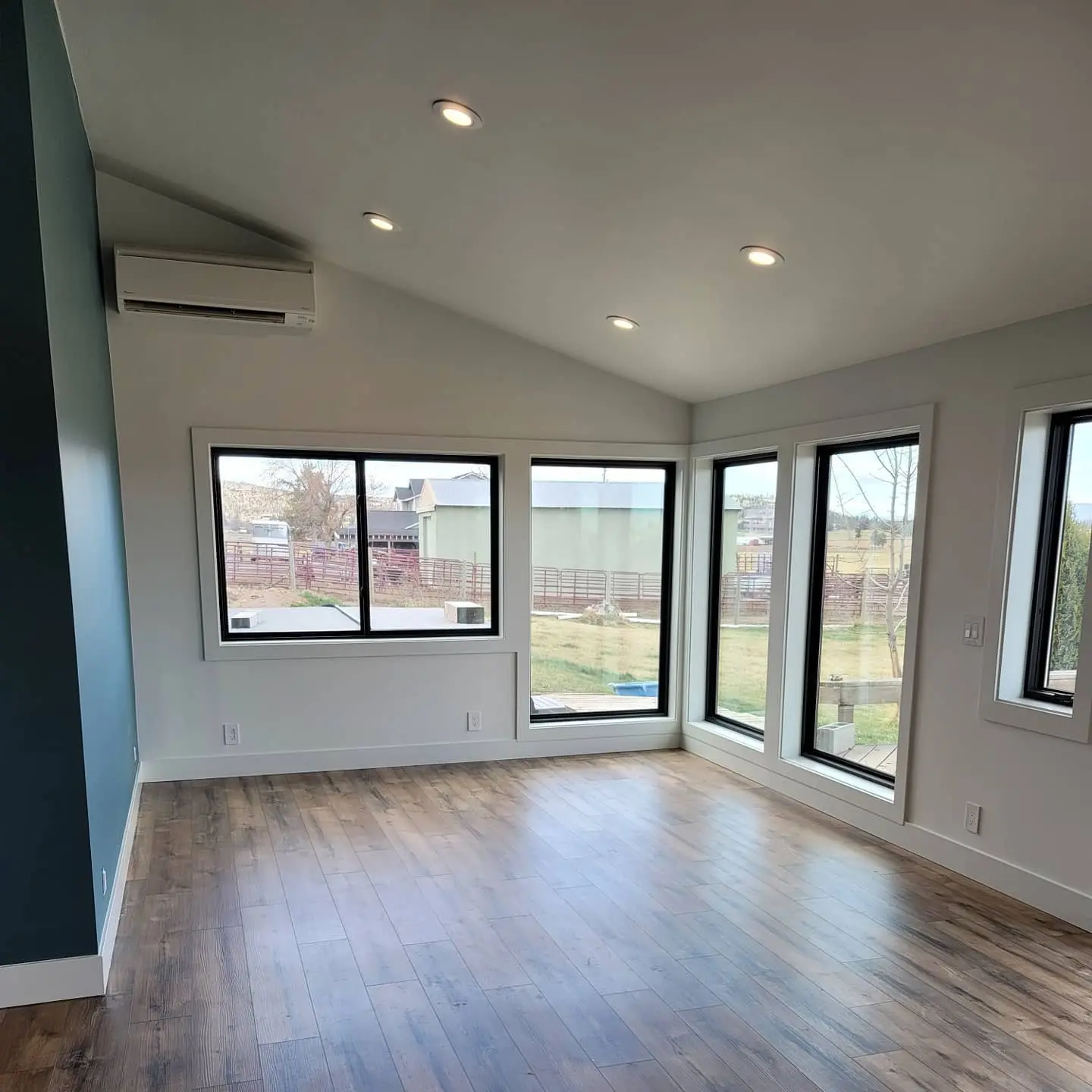 Bright interior room in Terrebonne, Oregon, with freshly painted white walls, recessed lighting, and large black-framed windows.